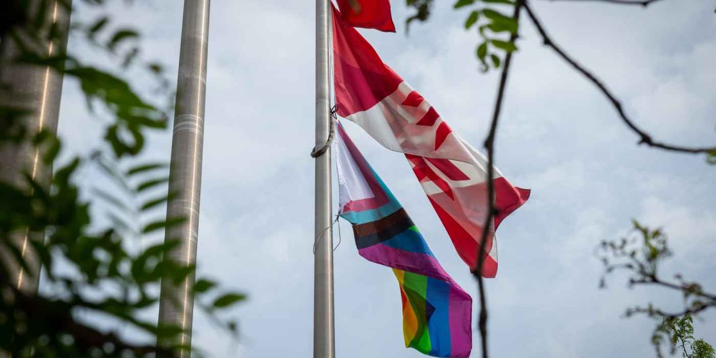 Pride flag and Fanshawe flag flying together
