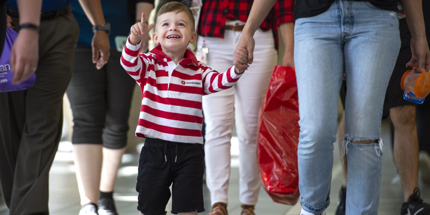 child pointing upwards and smiling
