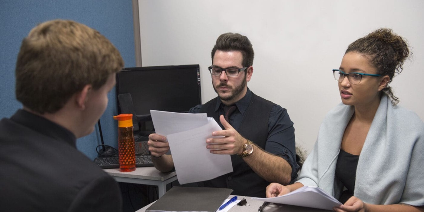 man and woman look at paperwork during employment interview