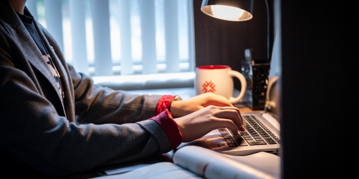 Student typing on a laptop at a desk
