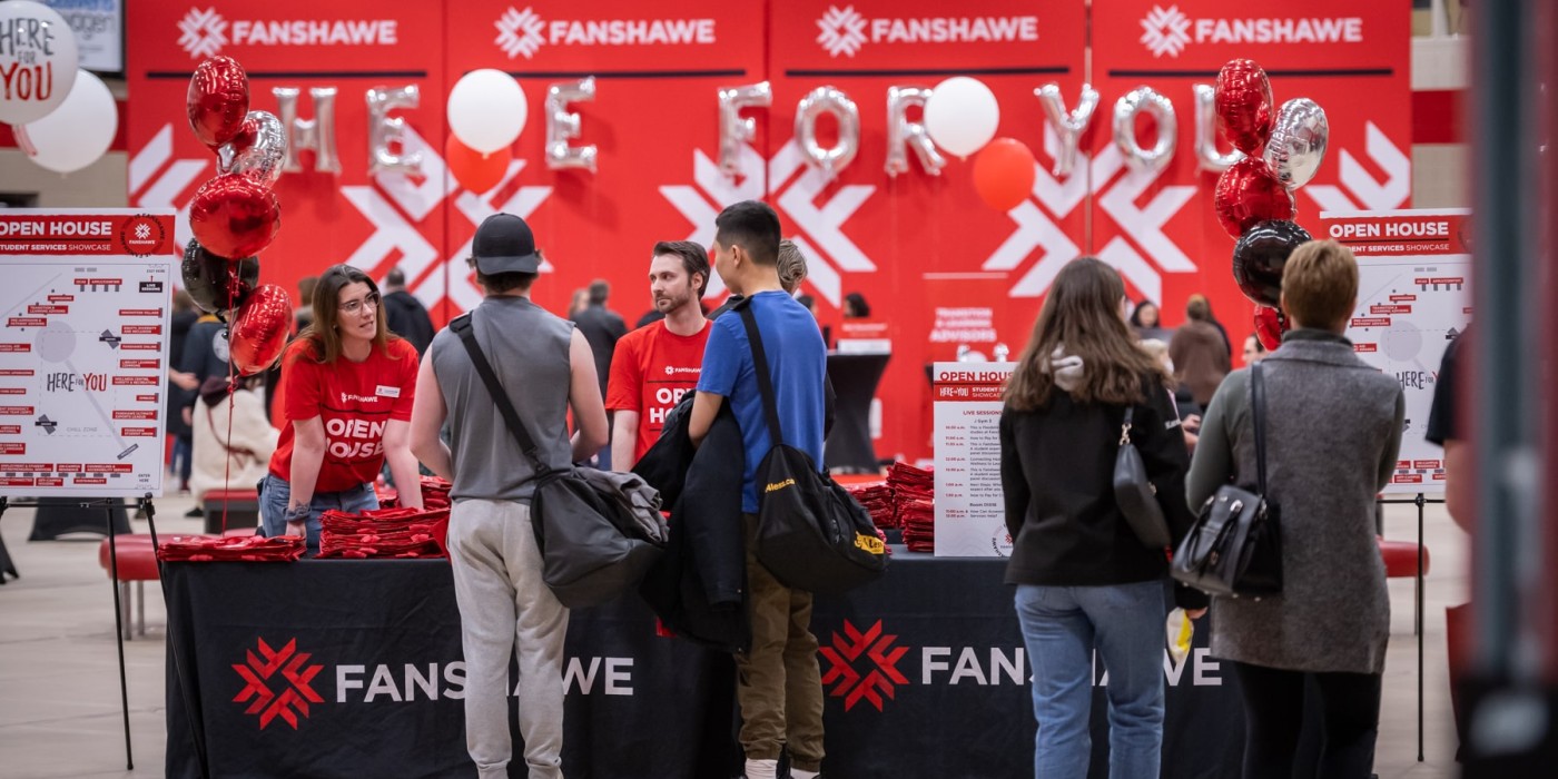 People standing at a welcome desk at open house