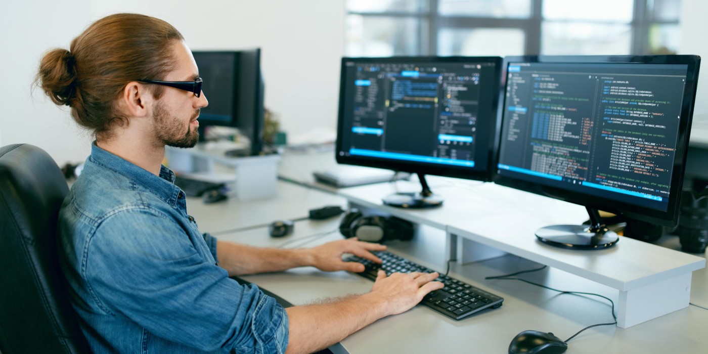 man looks at code on a computer