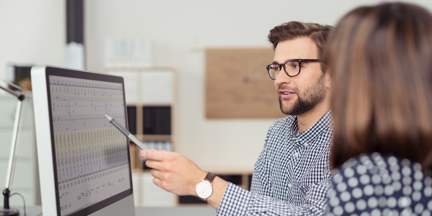 Researchers reviewing data on a spreadsheet