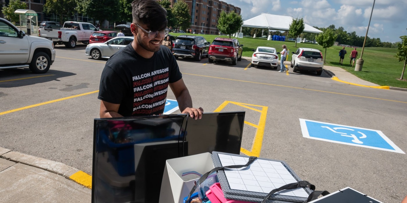 person pushes cart with belongings during move-in day