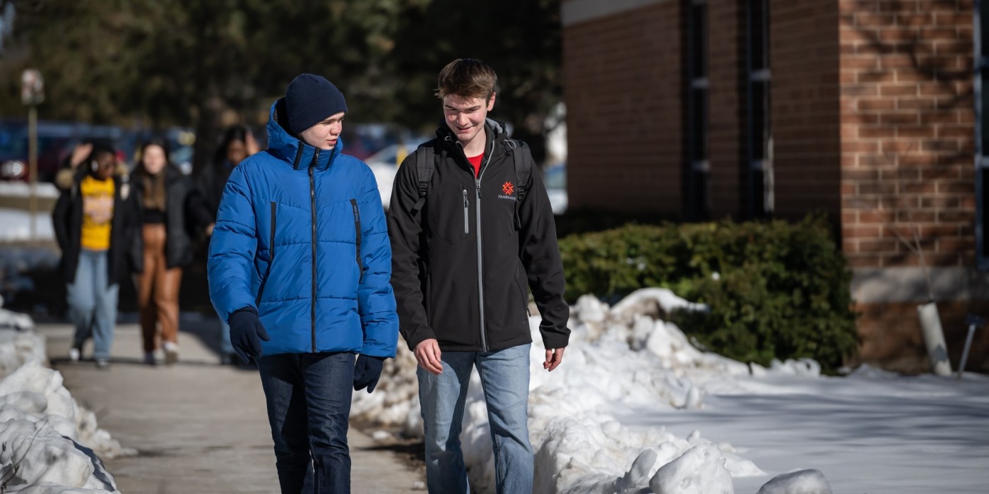 two students walking together in winter