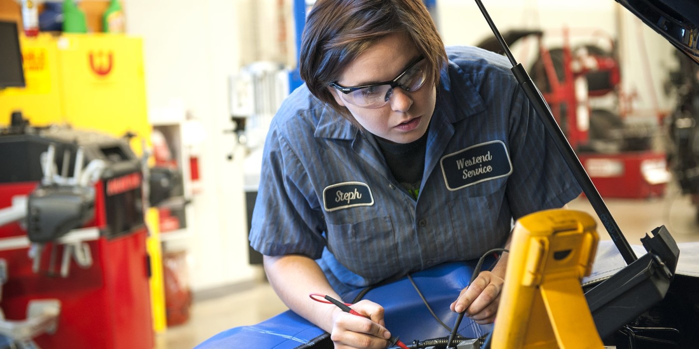 person testing electronics under the hood of a car