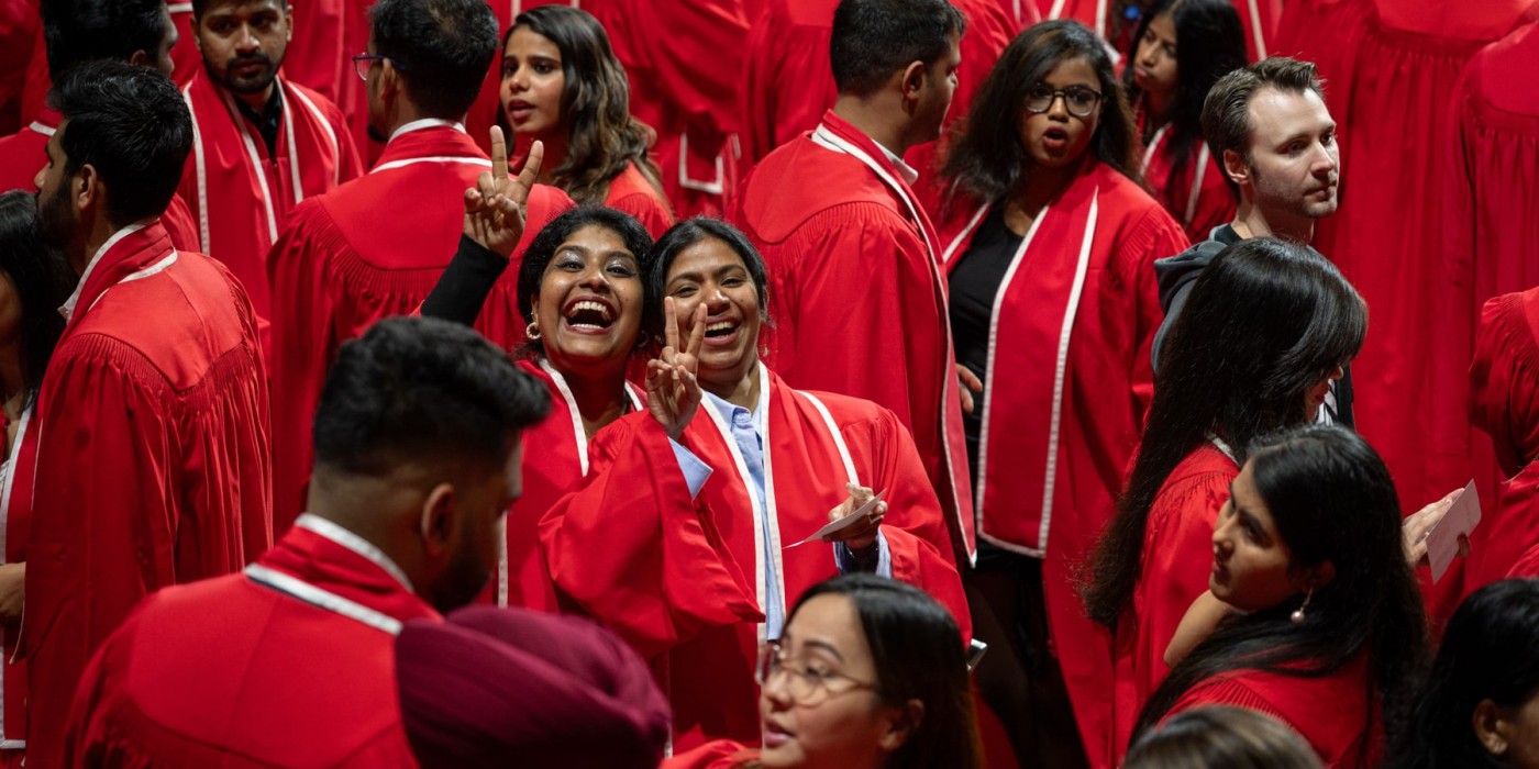 smiling graduates pose for cameras