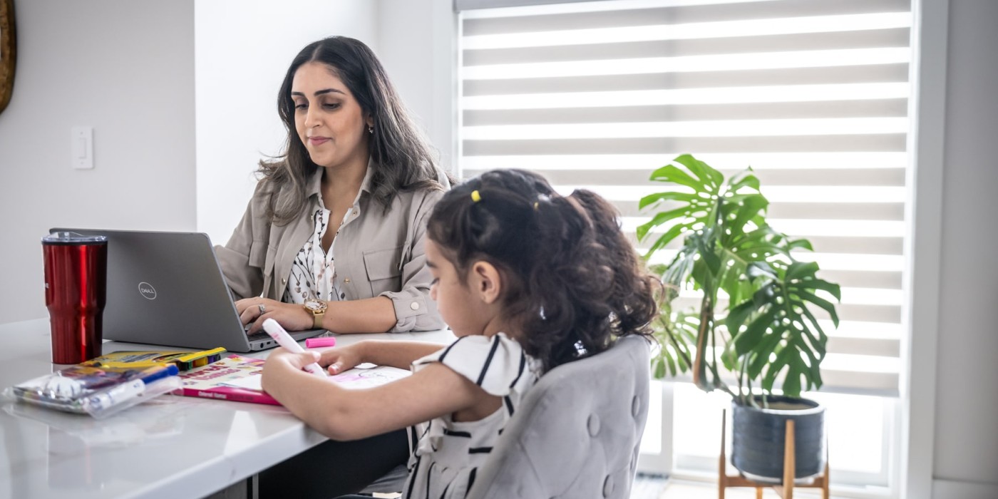 mother studies at dining room table next to child