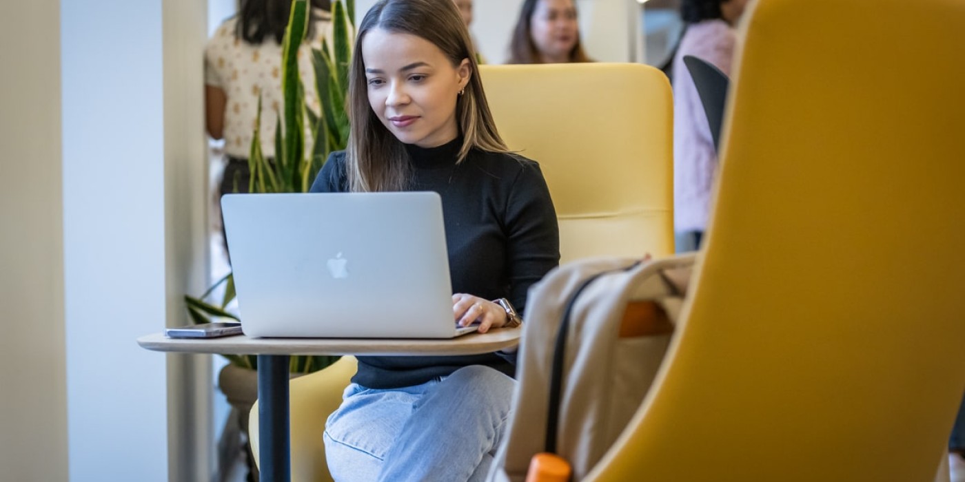 student sits in study space on laptop