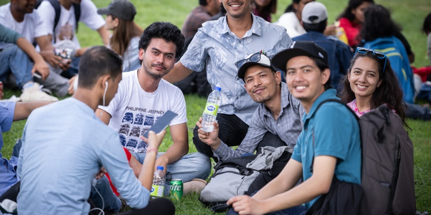 students sitting together on the grass at Fanshawe's orientation