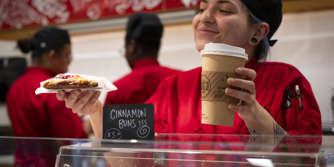 a barista is serving the coffee