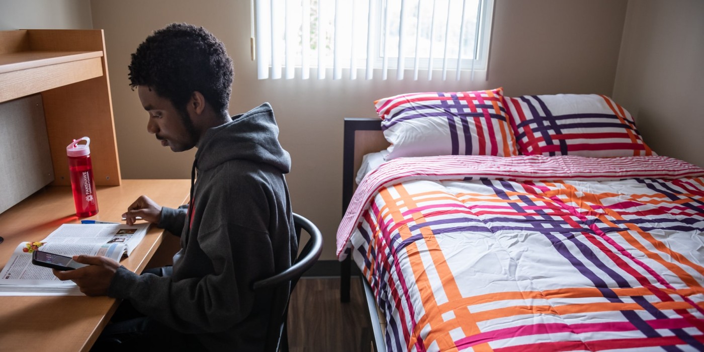 student sitting in residence room studying during reading week