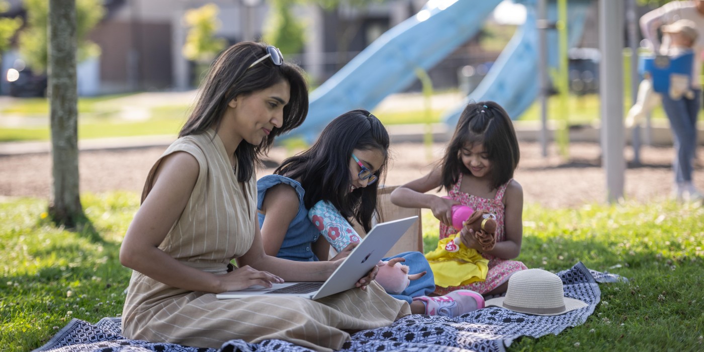 Learning Mom with the kids playing at a park