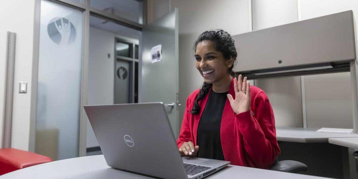 counsellor waves at camera during online appointment