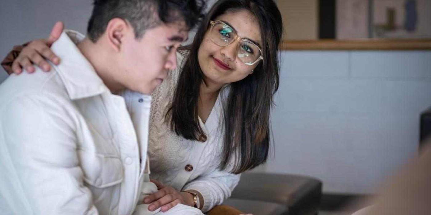 student puts their arm around another student