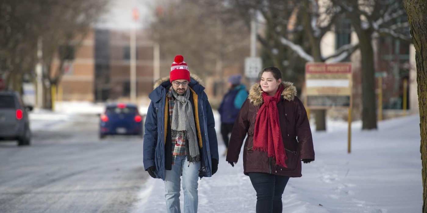 two students walk together at fanshawe in winter