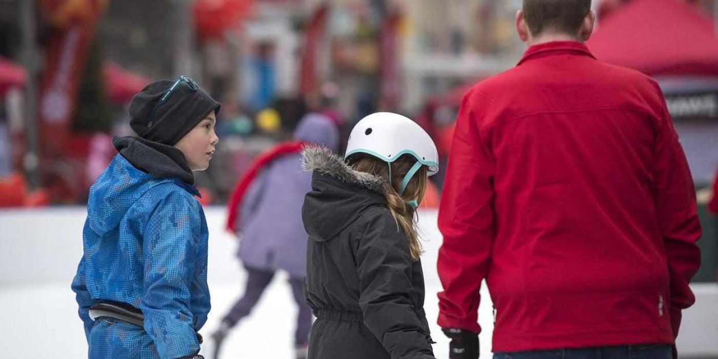 family skates together outdoors