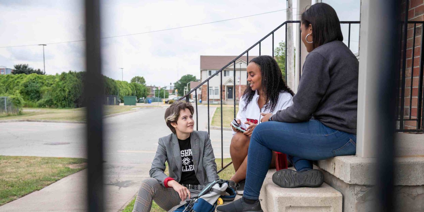 roommates sit together on steps having a discussion