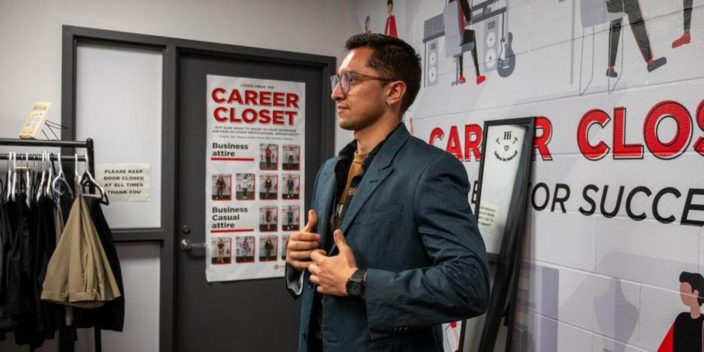 Photo of a student trying on a blazer at the career closet