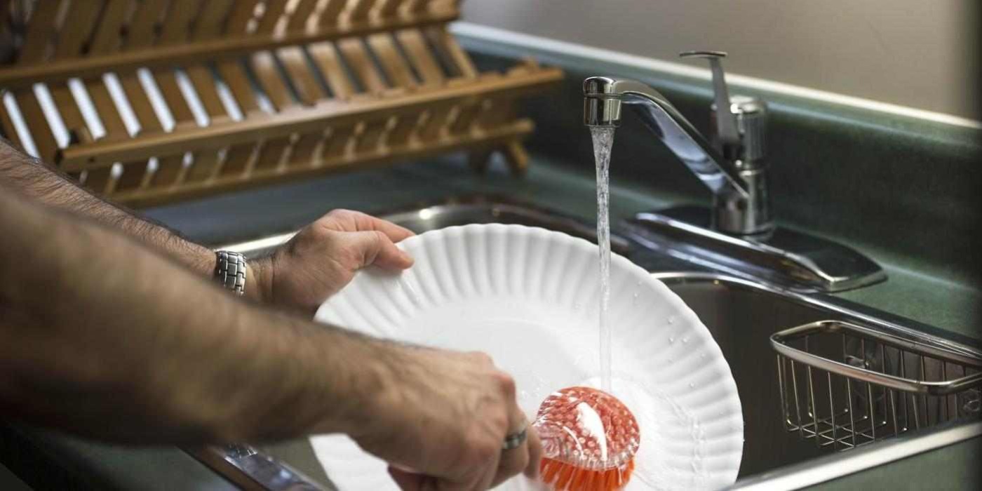 person washing a plate in a sink