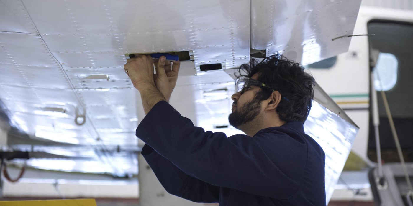School of Norton student working on the wing of an airplane