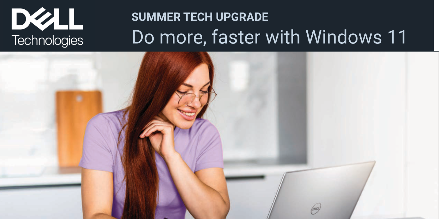 Woman with glasses sits with a laptop in front of her and taking notes with a pen on a notebook