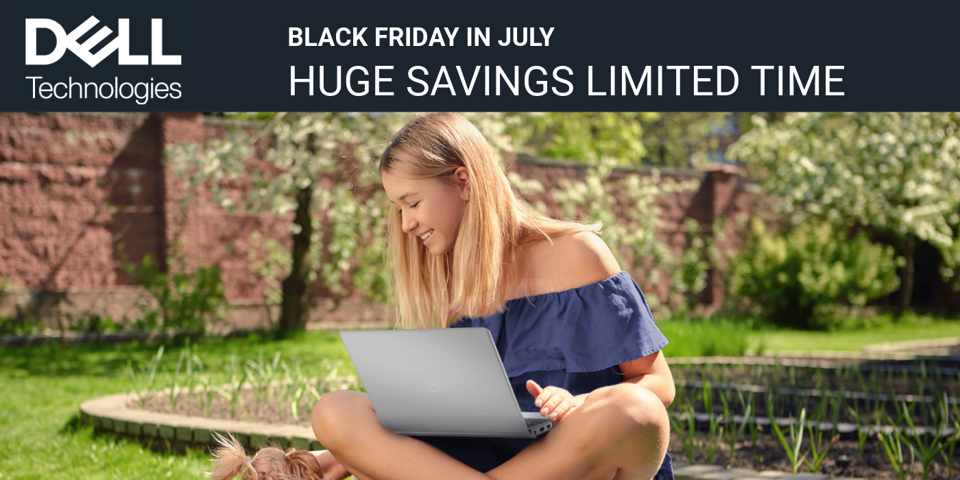 Woman sitting outside with a laptop on her lap as she sits crosslegged