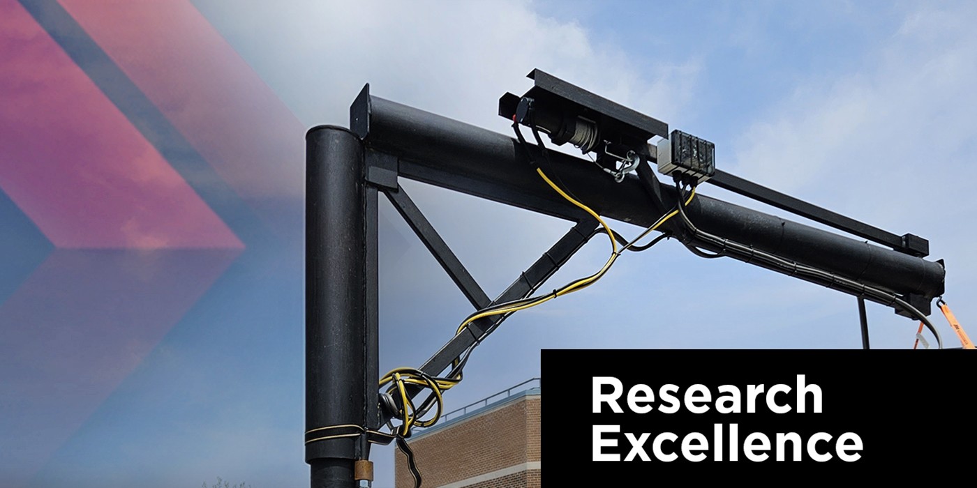 Closeup of a small crane with white text saying Research Excellence