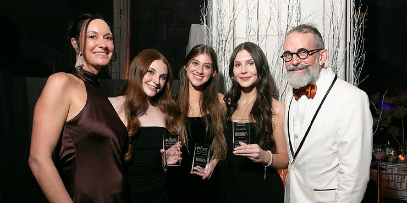 Three students in black dresses hold their PAVE awards as they celebrate with two representatives from the Hershey Company