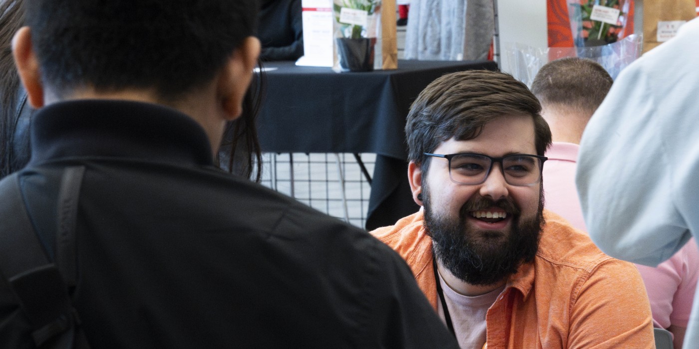 Image of a sitting and smiling man with a beard at a Fanshawe student event.