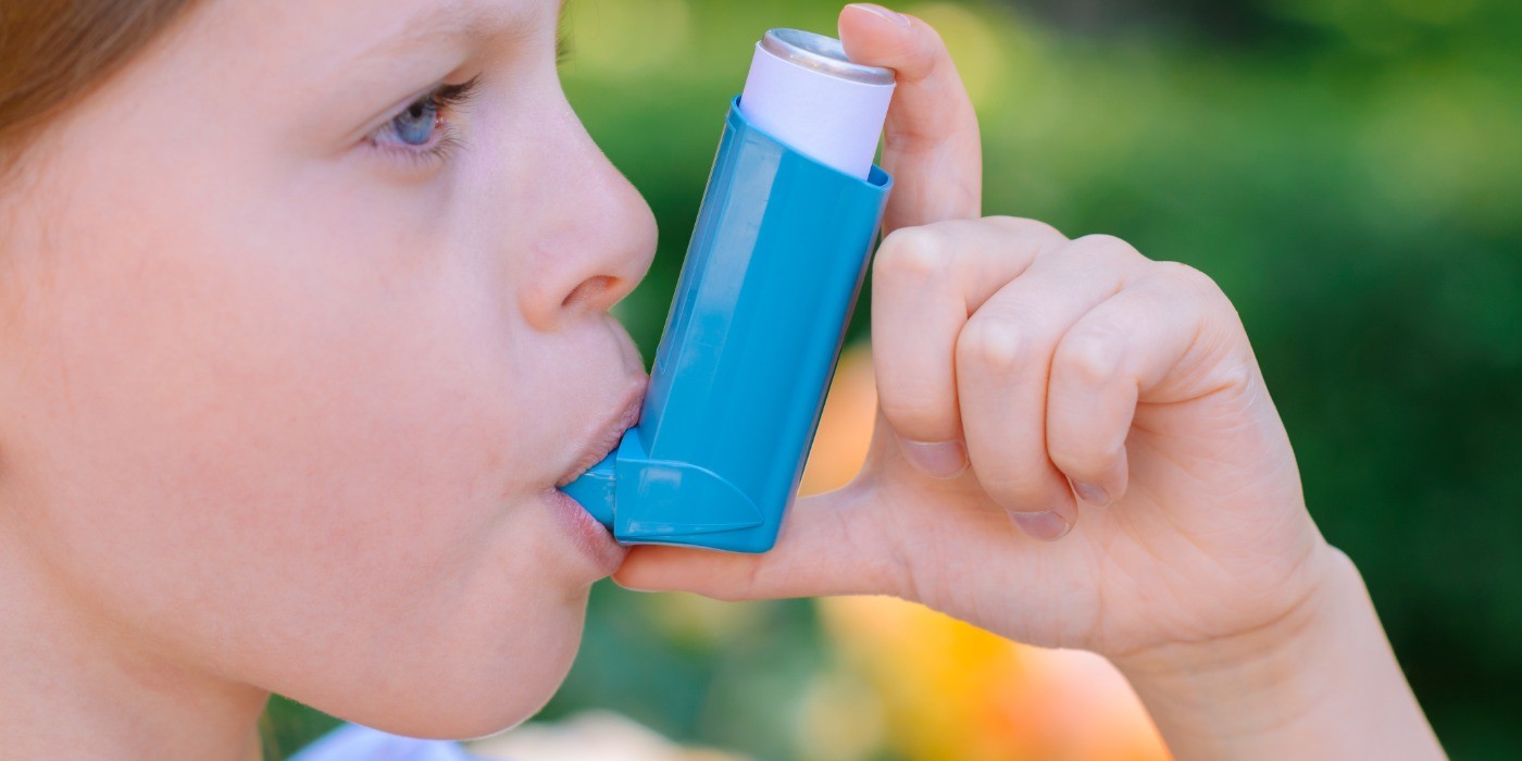 A young child makes use of a Metered Dose Inhaler to aid with breathing