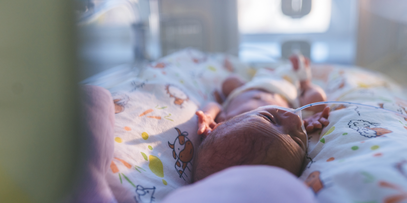 A baby inside an incubator in the NICE with wires attached to them