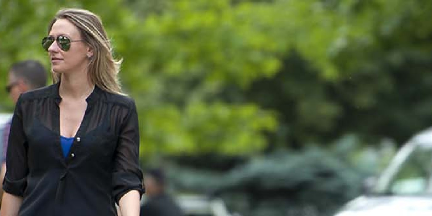 woman wearing sunglasses walking by other people