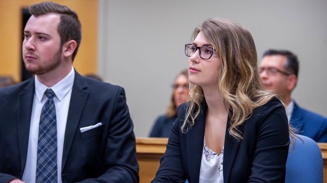 Two students in mock trial looking at judge