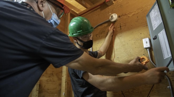 Instructor helping student with electric wiring