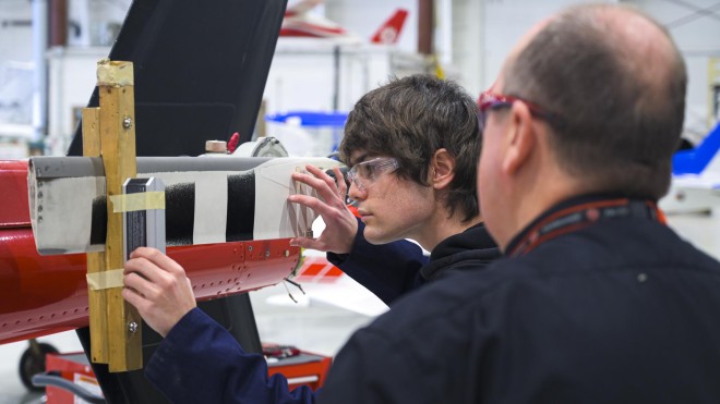 Aviation Technology - Aircraft Maintenance and Avionics student working with the help of instructor in lab