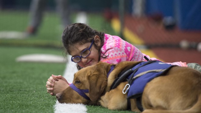 Young girl smiling, sitting with support dog