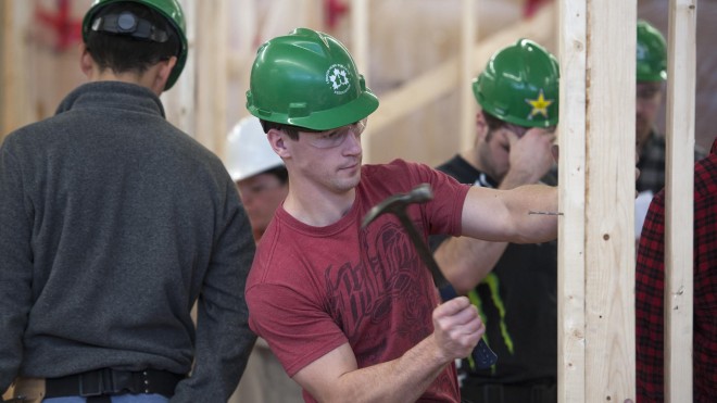 Fanshawe student hammering a nail into frame