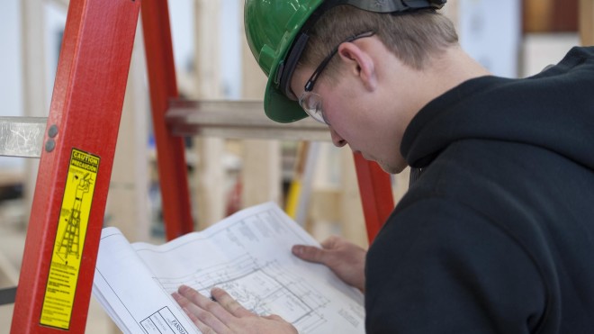 Fanshawe Carpentry student, reviewing plans in workshop