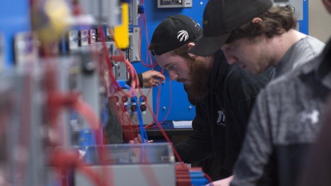 Students working in electronics lab at Fanshawe College with instructor assisting