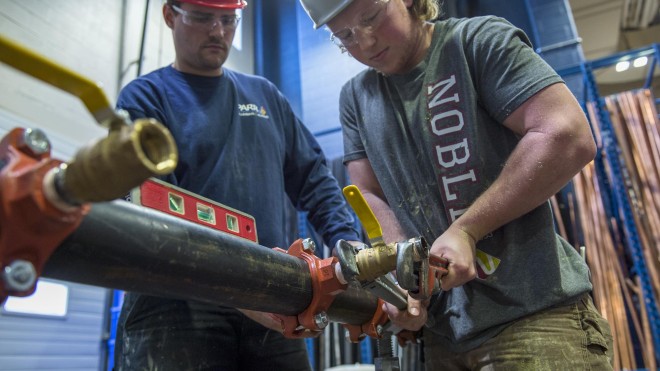 Fire Safety Systems students working on fire safety equipment