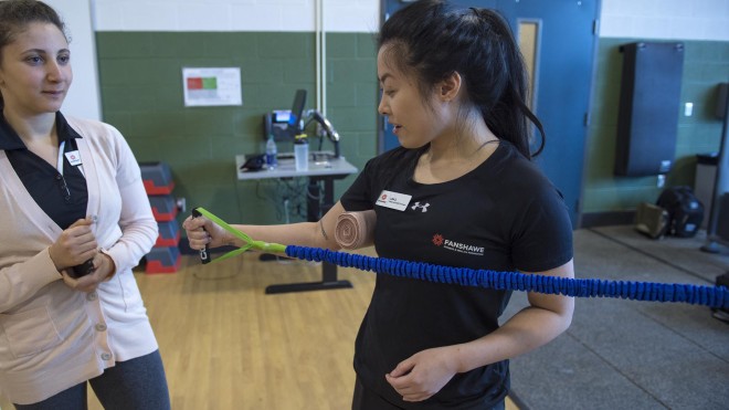 Fitness and Health Promotion student, doing arm exercises with band