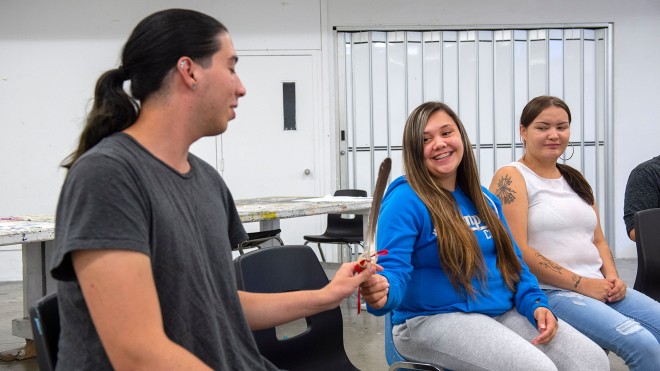 Student sitting a circle passing a feather around