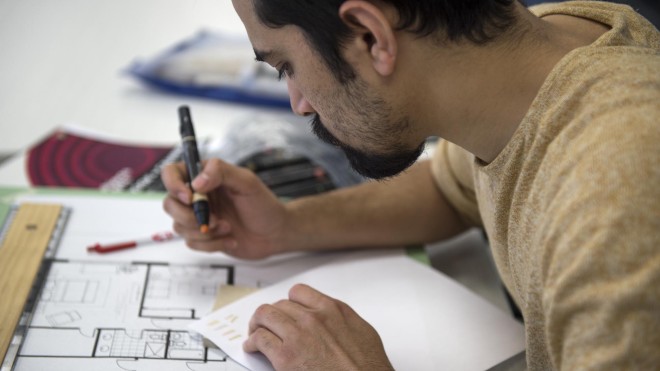 Student working on interior decorating assignment in class