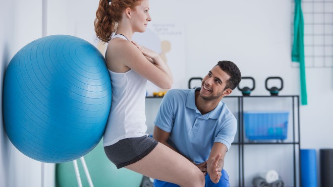 Occupational health therapist with a client showing her exercises