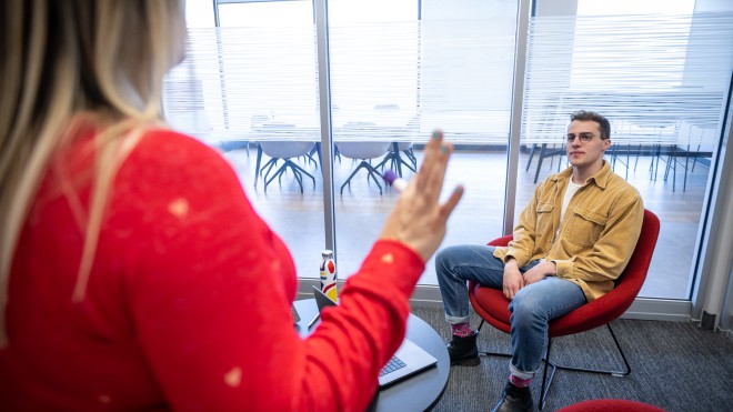 A male marketing student listening to a presentation while on co-op