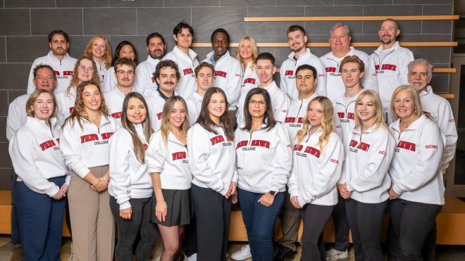 Students in white Fanshawe sweaters posting for a group photo.