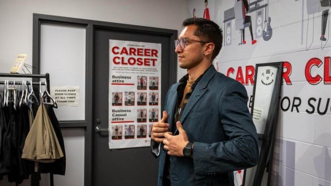 Photo of a student trying on a blazer at the career closet