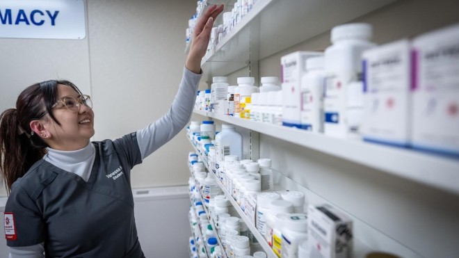 pharmacy assistant student organizes shelves of medication
