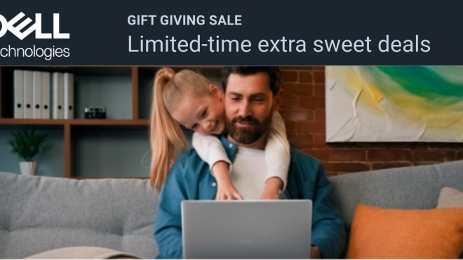 child leaning over father's shoulder looking at the dell laptop on his lap.